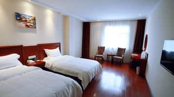 A hotel room with two beds, a TV, a desk, and a chair.