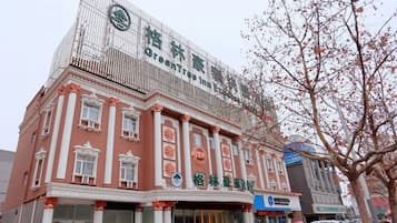 A building with a green logo and Chinese characters, indicating a hotel or similar establishment.