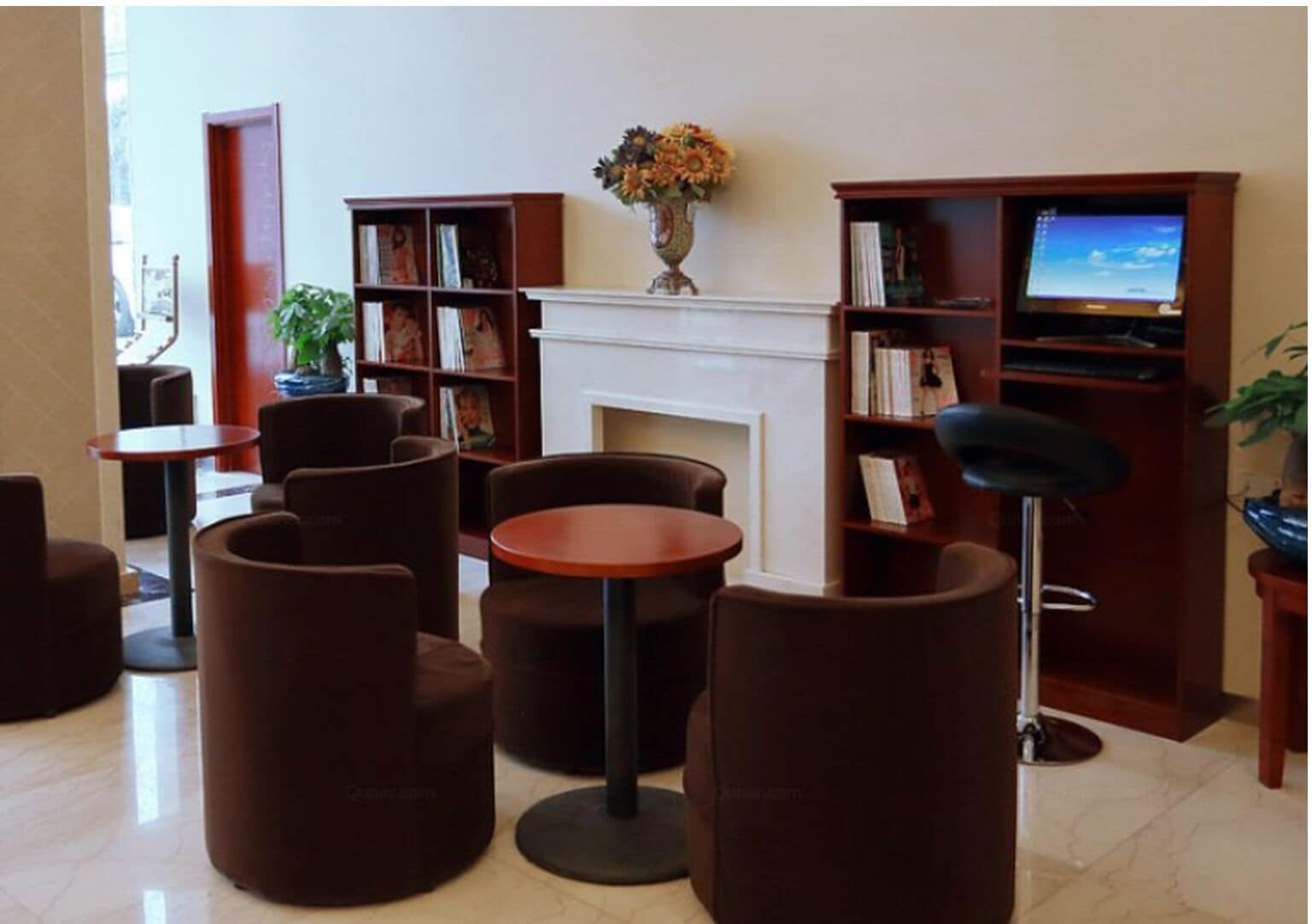 A library with bookshelves, a fireplace, and seating areas.