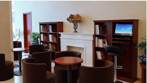 Una biblioteca con estanterías, chimenea y zonas de estar.