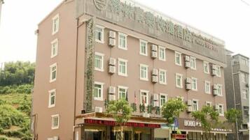 A multi-story hotel with a prominent sign, multiple windows, and a storefront with signage.