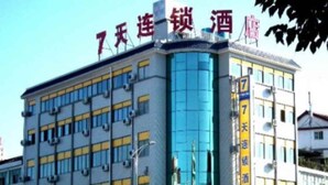 Un immeuble à plusieurs étages doté d’une façade en verre bleu, de plusieurs unités de climatisation et d’une enseigne indiquant qu’il s’agit d’un hôtel.