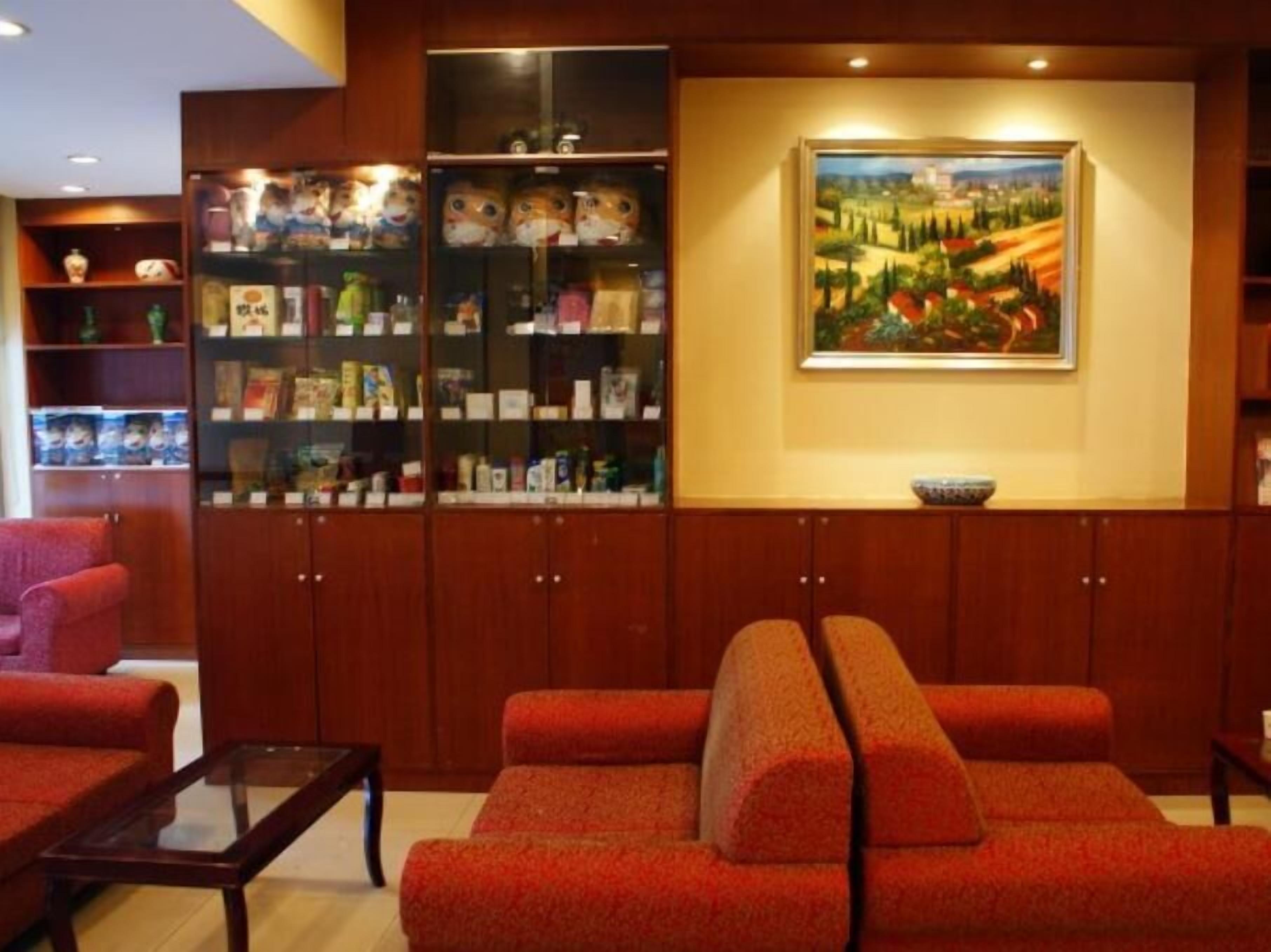 A room with a red sofa, a glass coffee table, wooden cabinets with glass doors, and a painting on the wall.