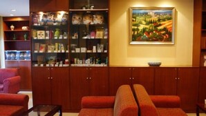 Um quarto com um sofá vermelho, uma mesa de centro de vidro, armários de madeira com portas de vidro e um quadro na parede.