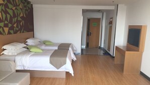A hotel room with two beds, a sofa, a TV, and a wooden floor. - Vatica Hotel (Xingtai)