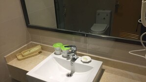 A bathroom with a white sink, a mirror, a toilet, and a towel rack. - Vatica Hotel (Xingtai)