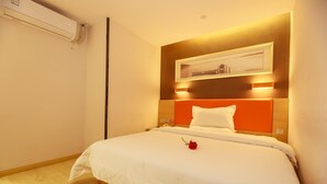 A hotel room with a bed, a bedside table, an air conditioning unit, and a wall-mounted light fixture. - 7 Days Premium Hotel (Chengdu)