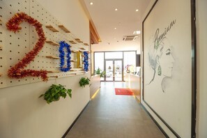 Un passadís amb una decoració penjada a la paret amb el número '2019', un retrat emmarcat i una porta que dona a l'exterior.