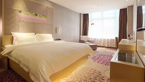 Une chambre d’hôtel moderne avec un grand lit, un bureau, une chaise et une grande fenêtre.