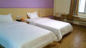 A hotel room with two beds, a desk, a chair, and a window with curtains. - 7 Days Inn Tangshan Haigang District Haicheng Road (Tangshan)