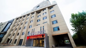 Un hotel de varios pisos con un letrero llamativo en la entrada.