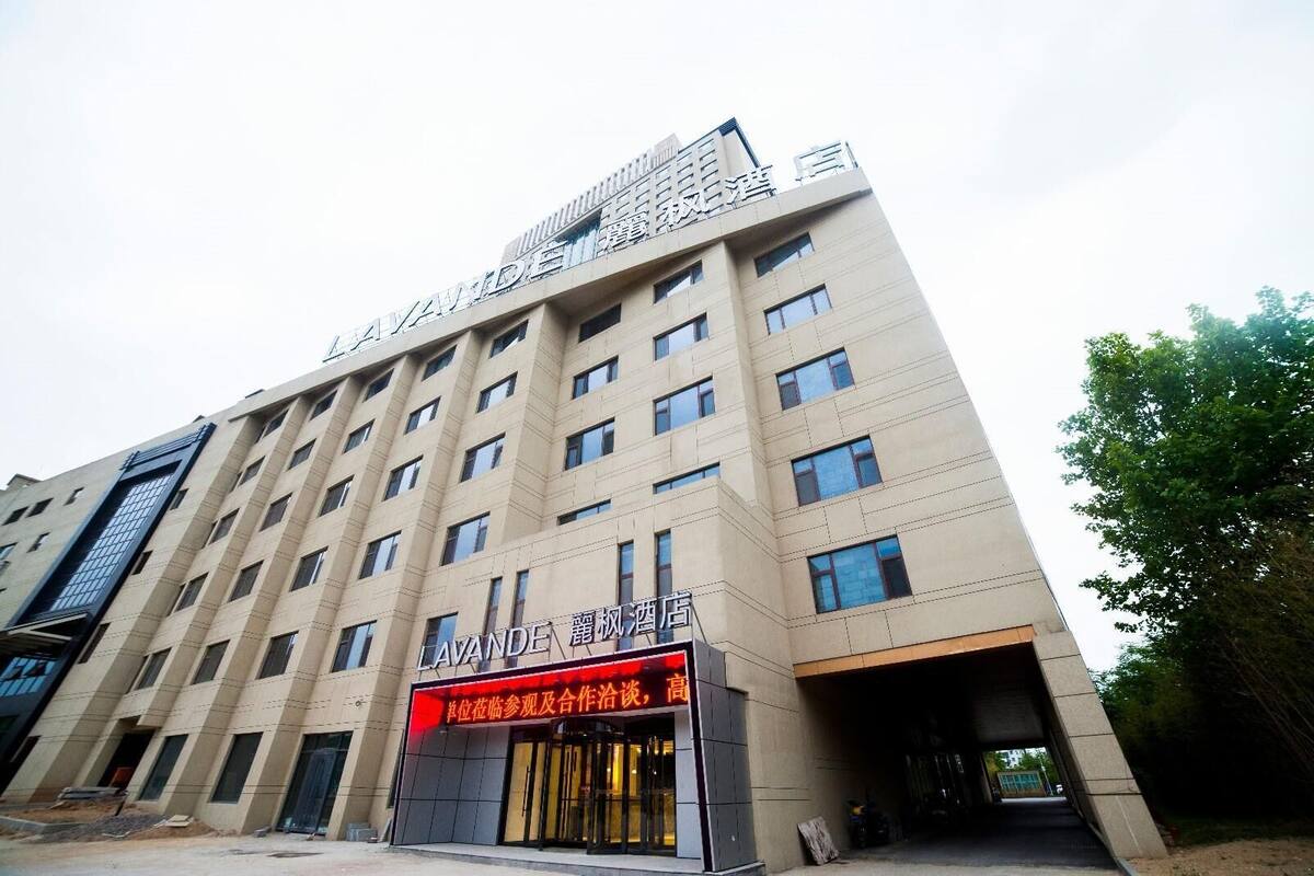 Ein mehrstöckiges Hotel mit einer gut sichtbaren Schilderung am Eingang.