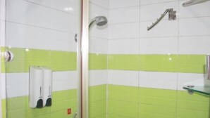 A bathroom with green and white tiles, a glass shower enclosure, and a hand dryer. - 7 Days Hotel Mafangshan Subway Station of Wuhan Jiedaokou University of Technology (Wuhan)