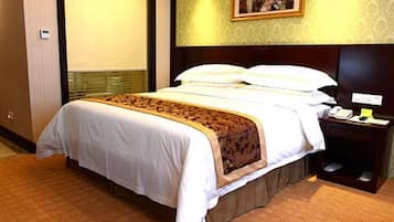 Una habitación de hotel con una cama, una mesita de noche, un teléfono y un cuadro en la pared.