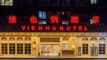 Fachada del Hotel Vienna de noche con señalización iluminada.