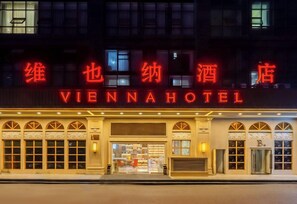 Hotellets facade i Wien om natten, med oplyst skiltning.
