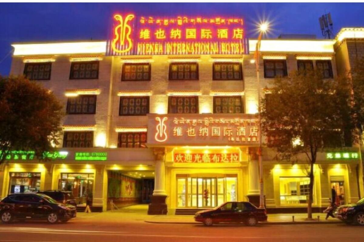 A hotel with multiple floors, illuminated signage, and a well-lit entrance.
