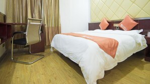 A hotel room with a bed, a chair, a headboard, and a curtain. - Shell Hotel (Dingxi)