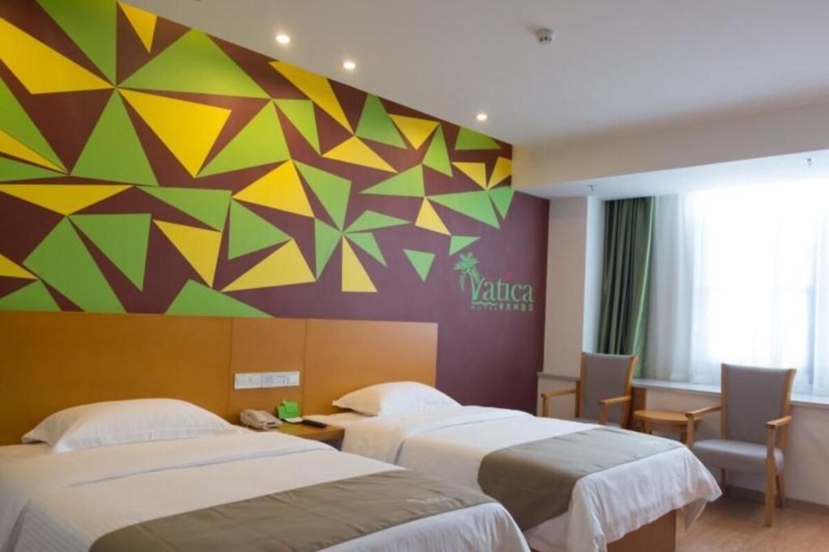 Una habitación de hotel con dos camas, un escritorio y una silla.