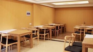 A conference room with wooden tables and chairs, a whiteboard, and a clock on the wall. - Greentree (Fuyang)