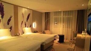 A hotel room with two beds, a sitting area with a chair and a small table, and a large window with curtains. - Lavande Hotels·tianshui Gangu Yicheng Square (Tianshui)