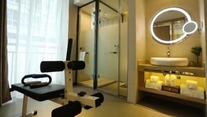 A modern bathroom with a glass shower enclosure, a round mirror with a light, and a white sink with towels. - Lavande Hotels·tianshui Gangu Yicheng Square (Tianshui)