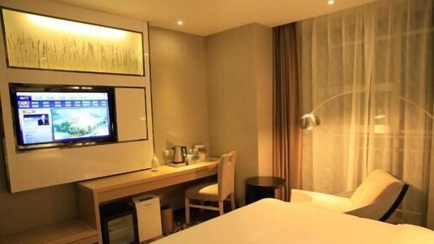 A hotel room with a bed, a desk with a computer, a chair, and a TV mounted on the wall. - Lavande Hotels·tianshui Gangu Yicheng Square (Tianshui)