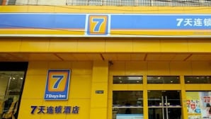 Entrada de hotel com uma placa grande com o número 7, indicando que faz parte da rede 7 Days Inn.