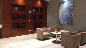 A modern lobby with a wooden wall, multiple seating areas, and a large cityscape artwork. - City Comfort Inn Shenzhen International Exhibition Center Tangwei Metro Station (Shenzhen)