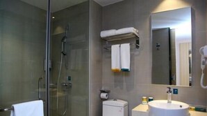 A modern bathroom with a glass-enclosed shower, a toilet, a sink, and a mirror. - City Comfort Inn Shenzhen International Exhibition Center Tangwei Metro Station (Shenzhen)
