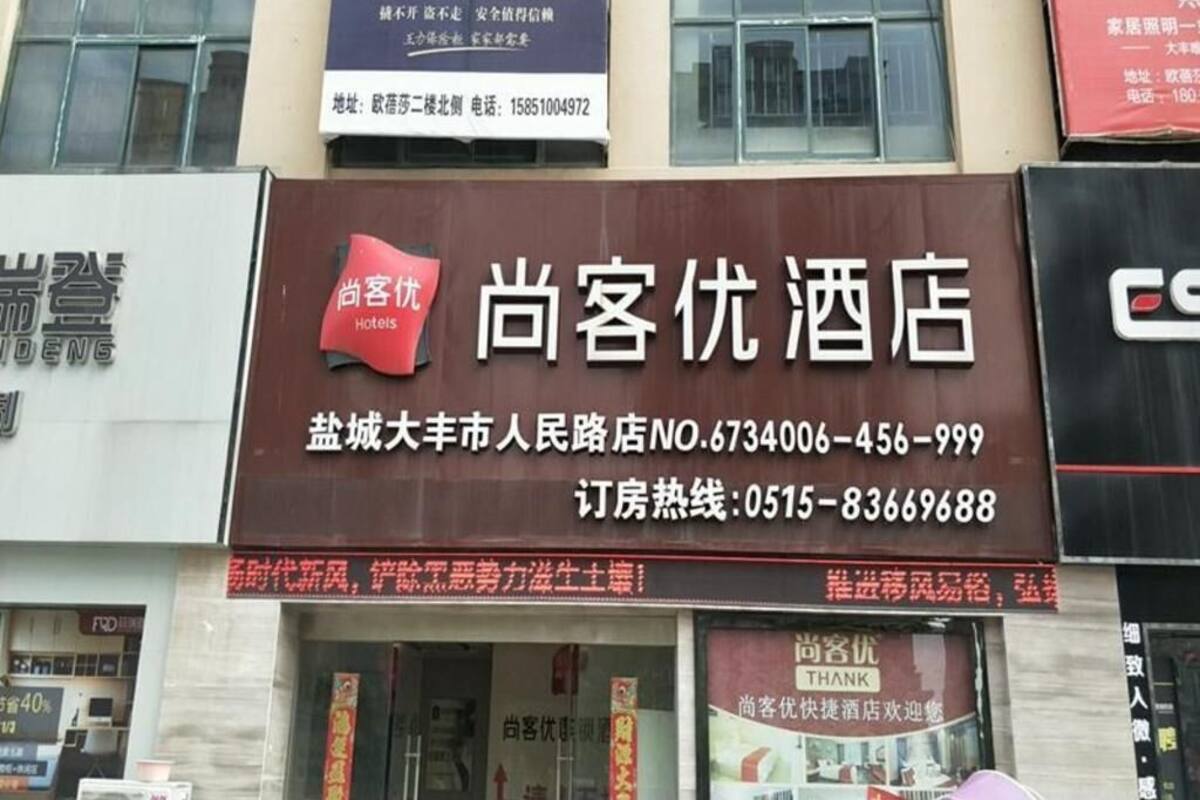 Un letrero de hotel con información de contacto y una etiqueta roja que dice 'HOTELES'.