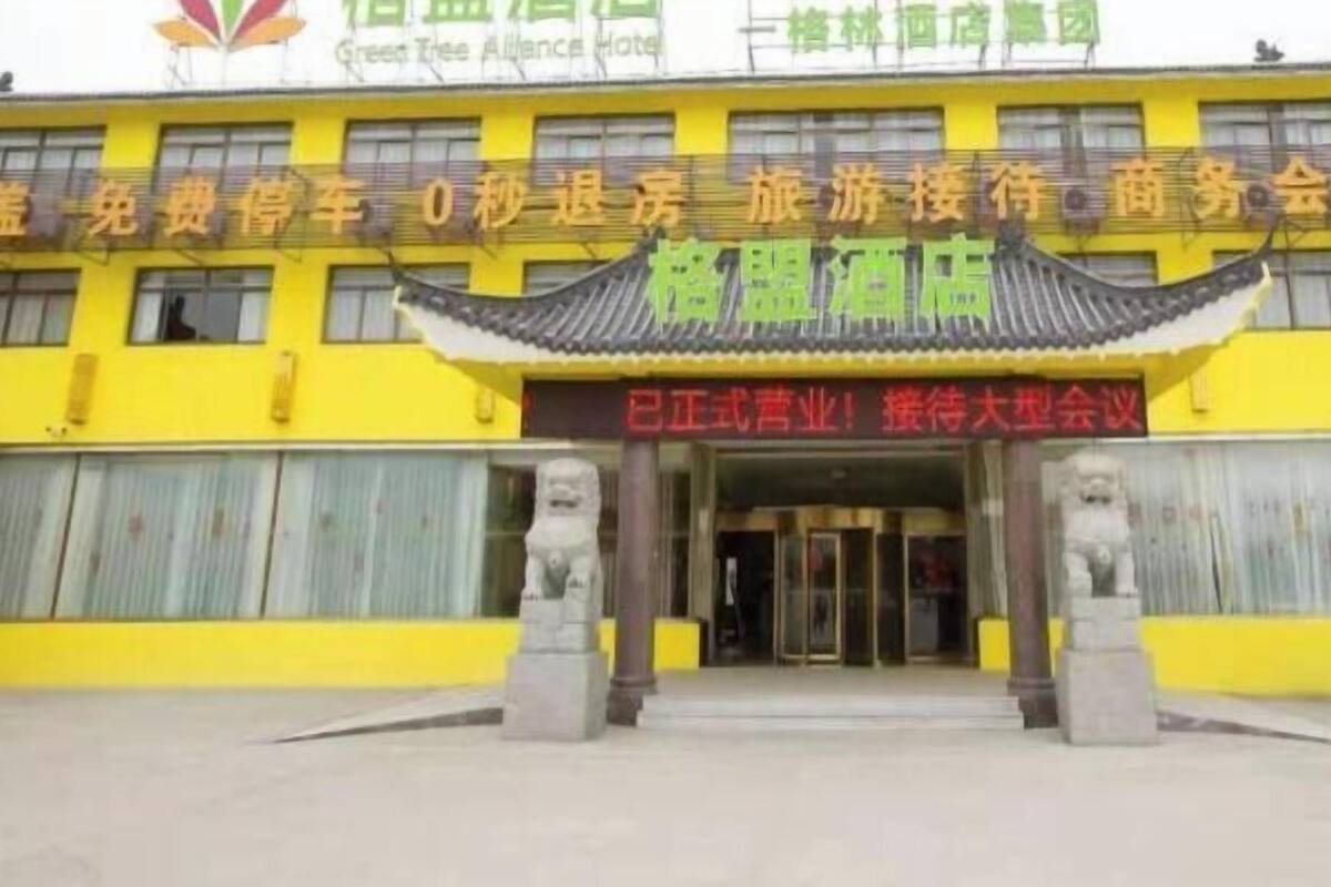Ein Hotel mit traditioneller chinesischer Architektur, großen Fenstern und einer auffälligen Schautafel.