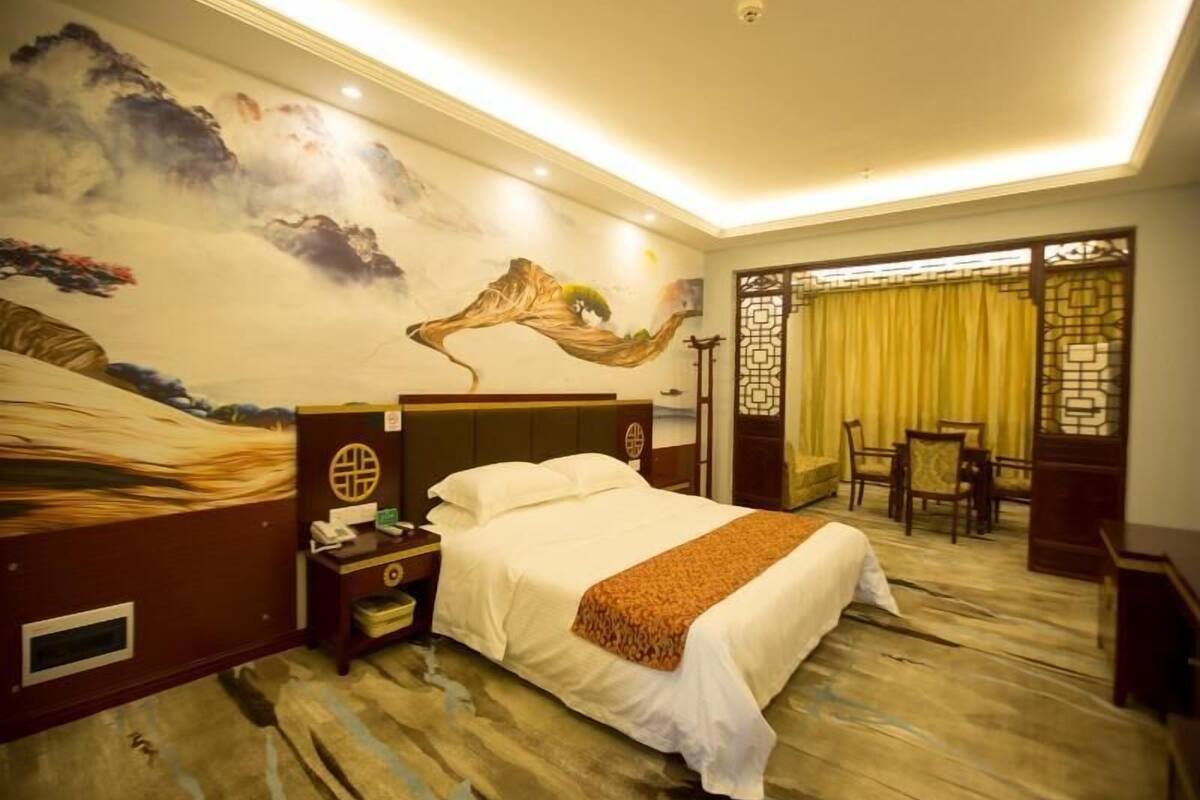 Ein Hotelzimmer mit Bett, Nachttisch, Schreibtisch und Stuhl.