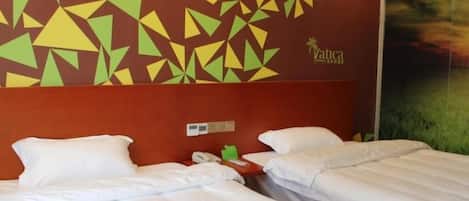 Habitación de hotel con dos camas, cabecera roja y diseño geométrico en la pared.