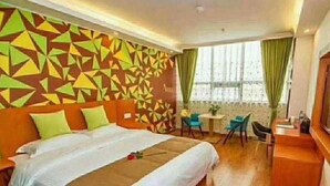 A hotel room with a large bed, a desk, and a chair. There is a window with curtains. - Vatica Hotel Fuyang Linquan Tenghui International City Branch (Fuyang)