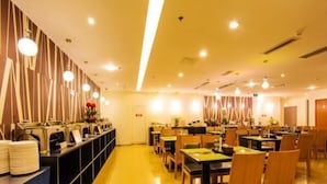 Un ristorante con diversi tavoli e sedie, un bancone con il menù e una parete decorativa.