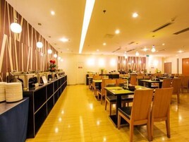 Un restaurante con varias mesas y sillas, una barra con menú y una pared decorativa.