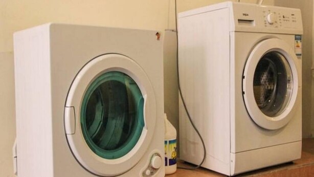 Two front-loading washing machines in a laundry room. - 7days Inn Chain Hotel (Beijing)