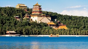A traditional multi-tiered pagoda on a hill with a body of water in the foreground. - 7days Inn Chain Hotel (Beijing)