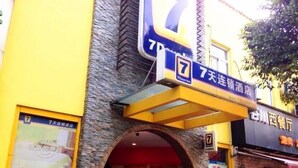 Fachada de hotel de piedra, con un arco circular grande y señalización que indica el nombre del hotel y sus servicios.