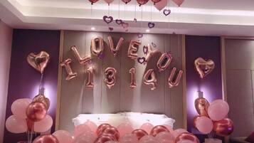 Una habitación con una cama, globos y una pared donde se lee 'I LOVE YOU' con globos.