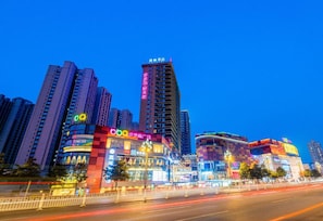 A high-rise building with illuminated signage and a busy street with light trails. - Lavande Hotels Luzhou Bubugao Xintiandi (Luzhou)