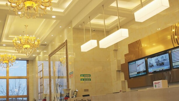 A hotel reception area with a chandelier, a reception desk, and a large window. - Greentree Inn Express (Dalian)