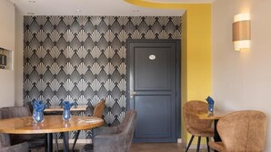 Un comedor con pared de diseño, una puerta oscura y una pared de acento amarilla.