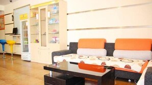 A living room with a sofa, a coffee table, a cabinet with shelves, and a chair.