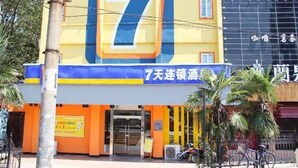A building with a large number '7' on the facade, a covered entrance, and a sign with Chinese characters.