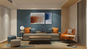 A modern living room with a sofa, armchair, coffee table, and decorative pillows. - Holiday Inn Express Qiliping by IHG (Leshan)