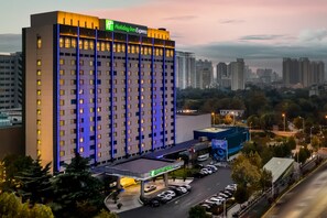 Ein Holiday Inn Express Hotel mit modernem Design, mehreren Etagen und einem Parkplatz.