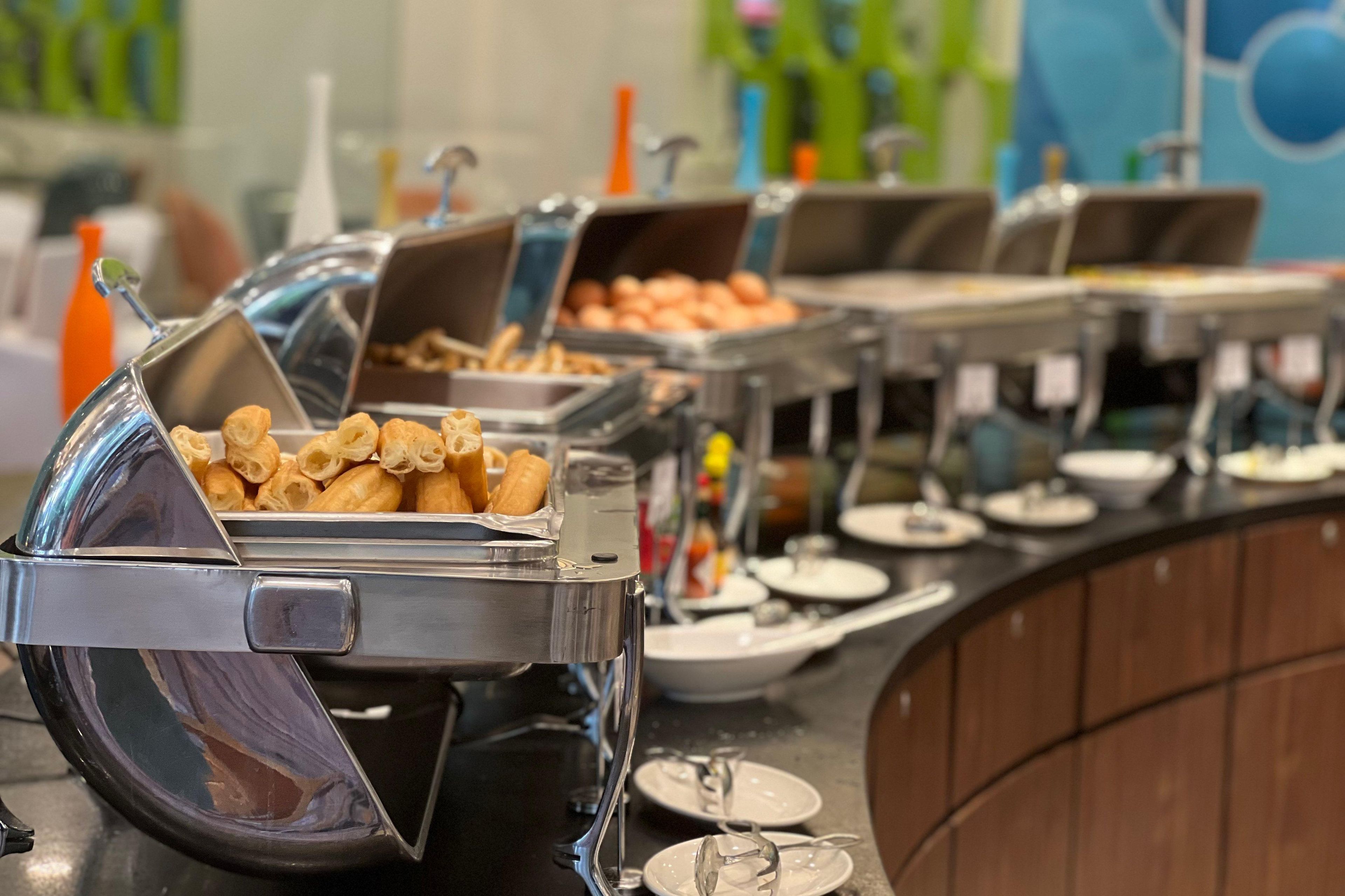 Montaje de bufé con diversas opciones de comida, incluyendo pasteles y un dispensador de bebidas.