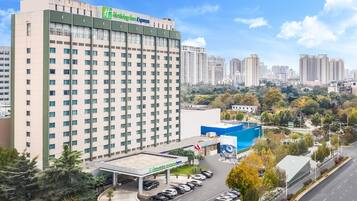 Um hotel com design moderno, área de estacionamento e vista para a paisagem urbana circundante.